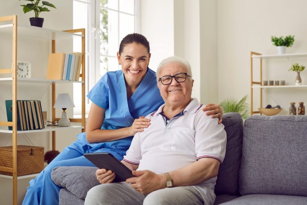 Caregiver hugging an older man in a senior living community